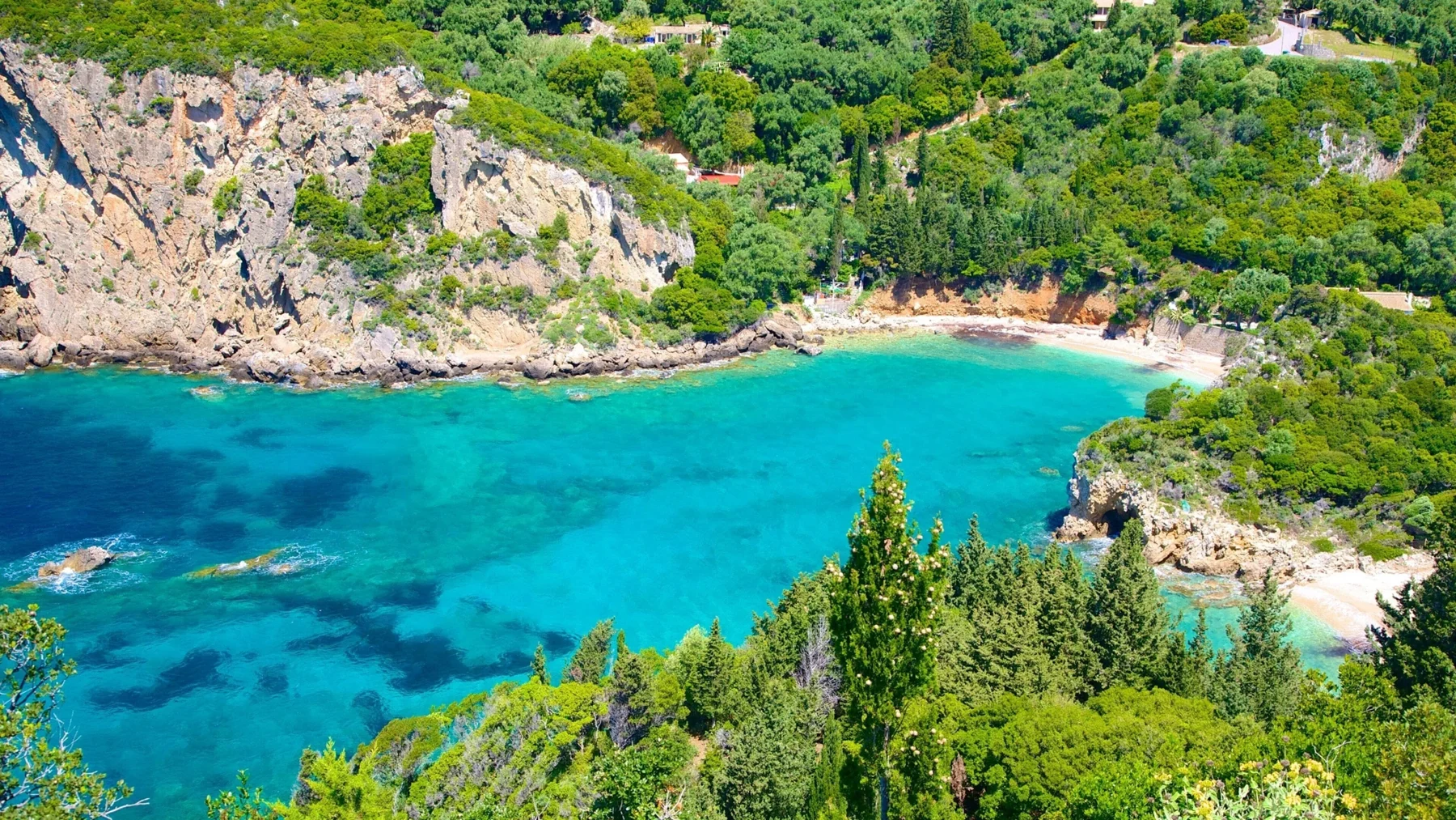 Turquoise waters and green cliffs at Paleokastritsa in Corfu, from Martaki’s destination photography—not apartment interiors